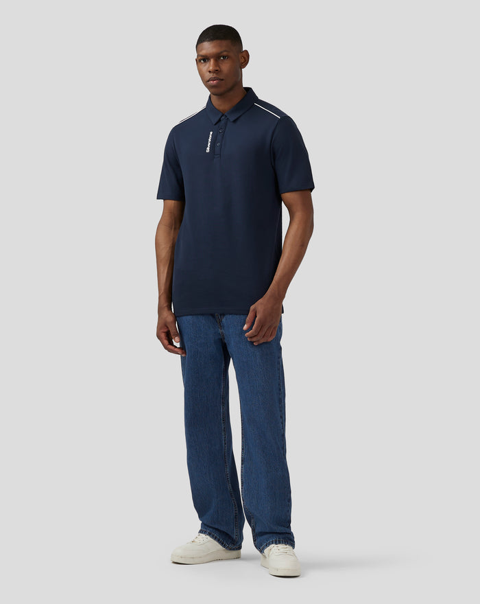Male model wearing navy Silverstone Core Polo Shirt with white shoulder piping and hidden placket with vertical Silverstone print.