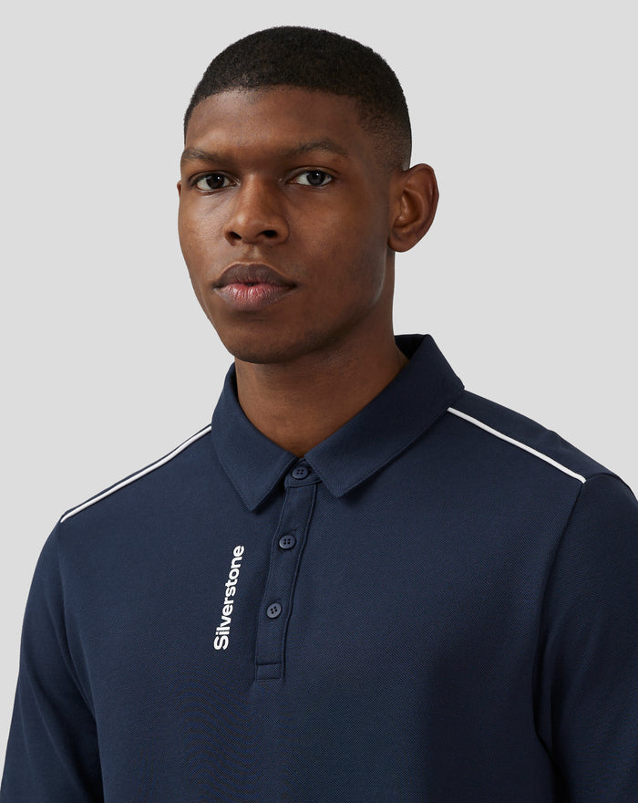 Near profile of model in navy polo with white piping on shoulder and Silverstone branding along the front placket