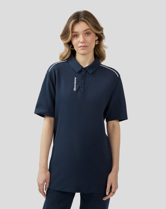 Front view of a woman in a navy polo with white piping on the shoulders and Silverstone branding on the placket.