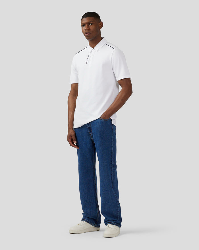 Male model wearing a white Silverstone Core polo shirt with black piping and chest graphic.