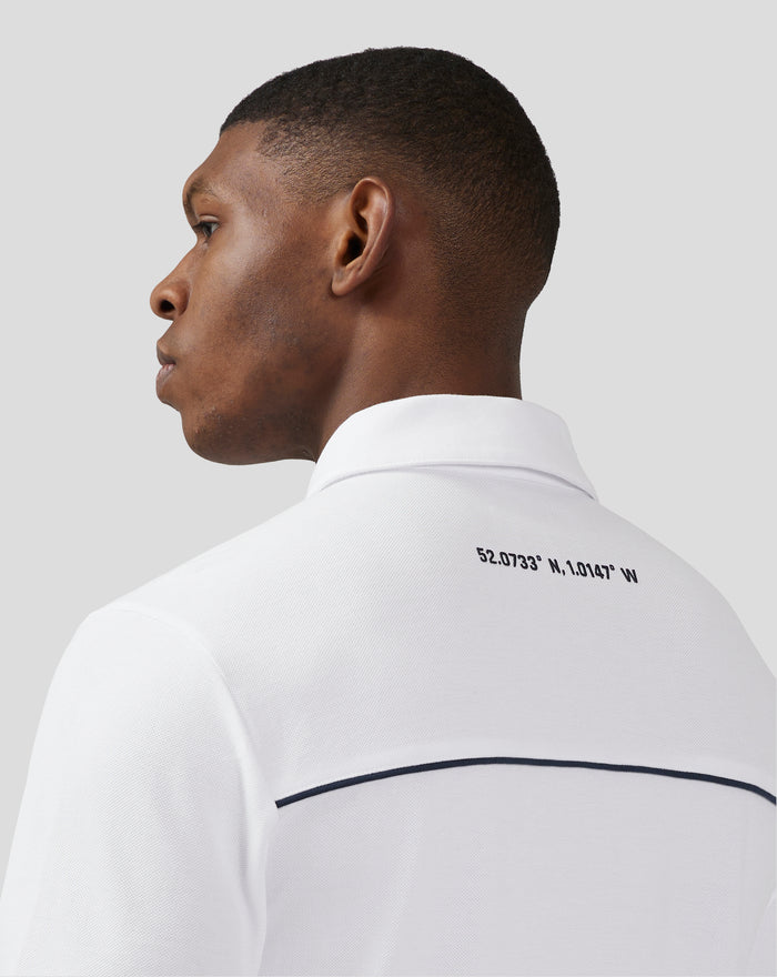 Male model wearing a white Silverstone Core Polo in side profile, showing collar and neck detail.