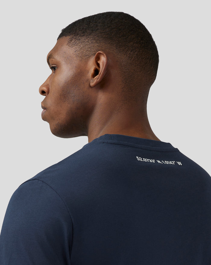 Profile view of a man wearing a navy Silverstone Core T-Shirt with back neck silicone print and coordinates on the upper back.