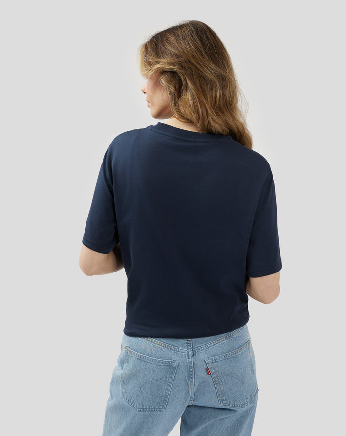 Rear view of model in navy Core 1948 T Shirt with light blue jeans and red back pocket tag