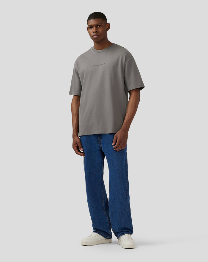 Front view of model in charcoal grey oversized T shirt with coordinates graphic on chest